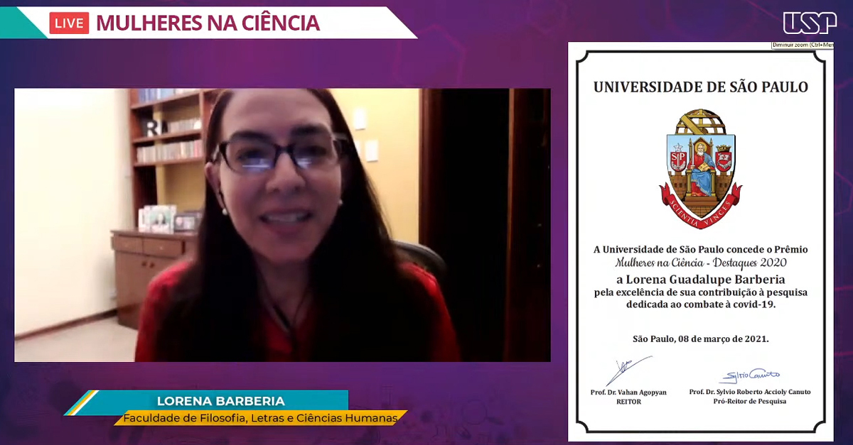 professora Lorena Barberia recebendo prêmio
