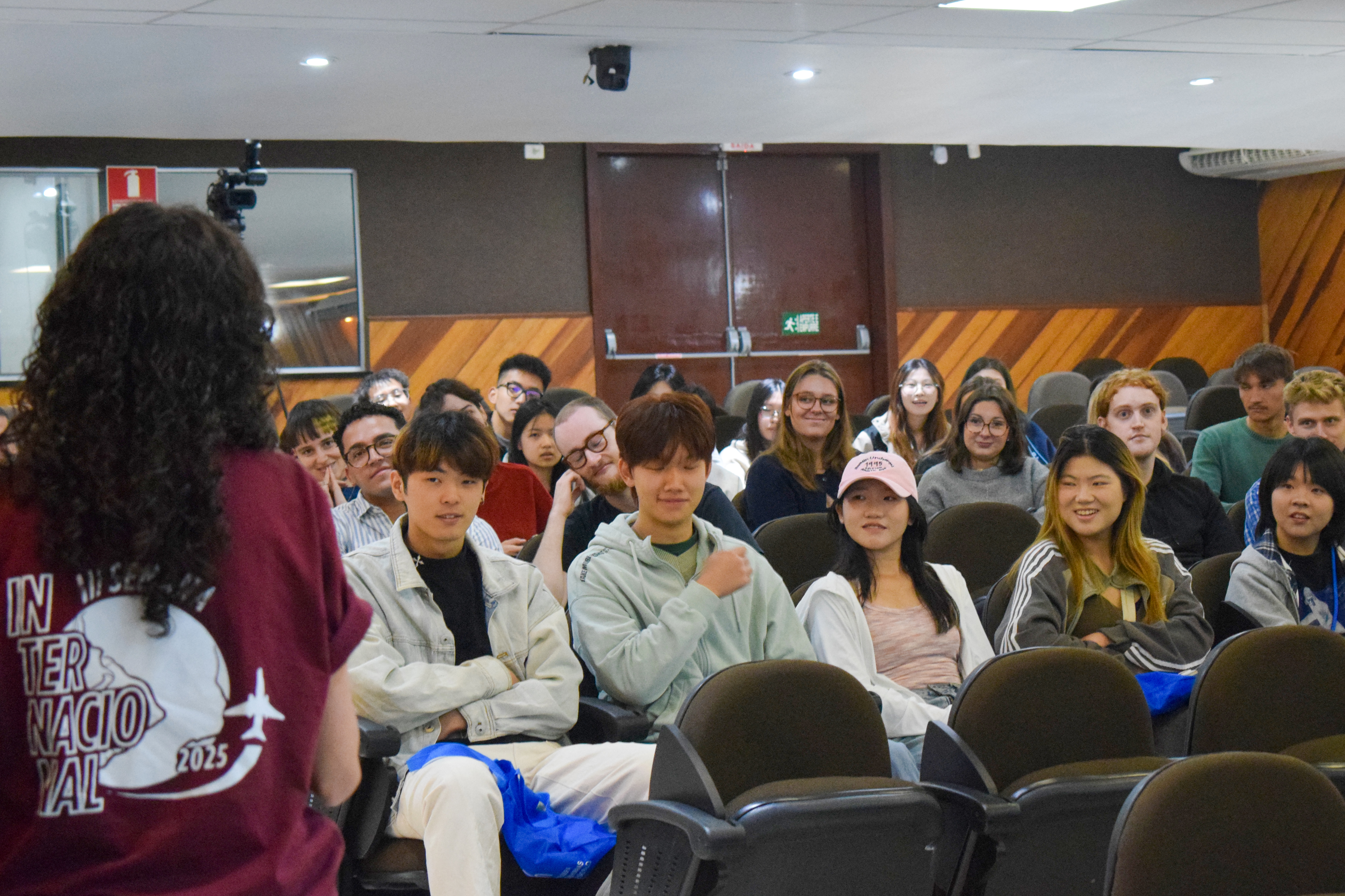 pessoas sentadas no auditório assistindo a apresentação