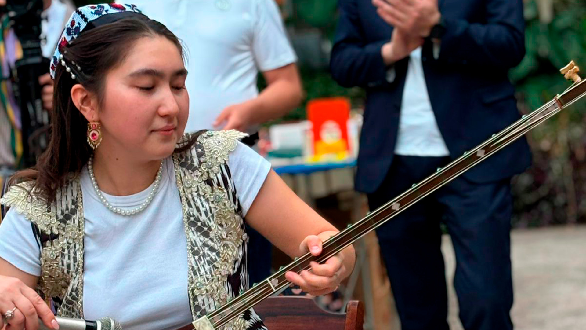 Mulher uzbequistanesa tocando instrumento de cordas